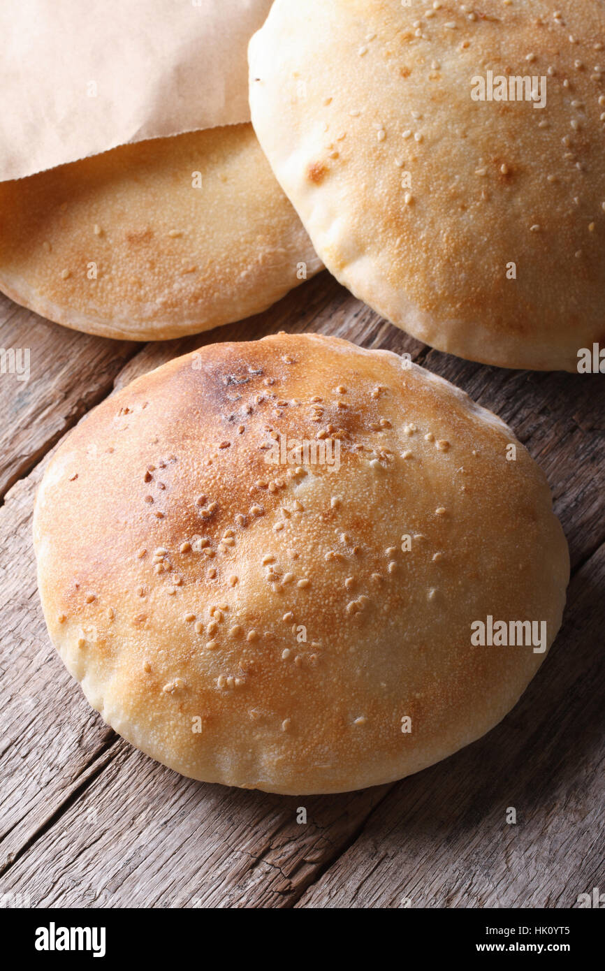 Pane appena sfornato pane pita su un tavolo di legno vicino la vista verticale da sopra Foto Stock