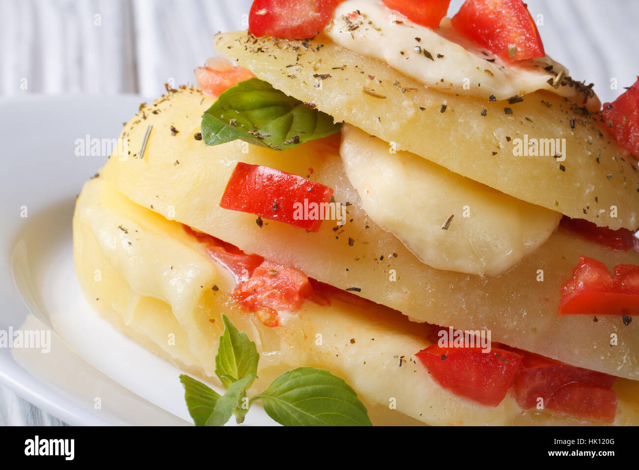 Patate novelle bollite farcite con mozzarella, pomodoro e basilico close-up orizzontale Foto Stock