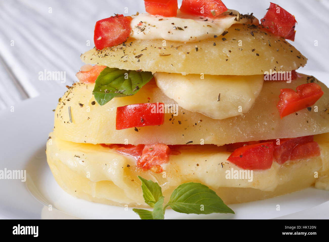 Fette di patate di primizia farcite con mozzarella, pomodoro e basilico close-up orizzontale Foto Stock