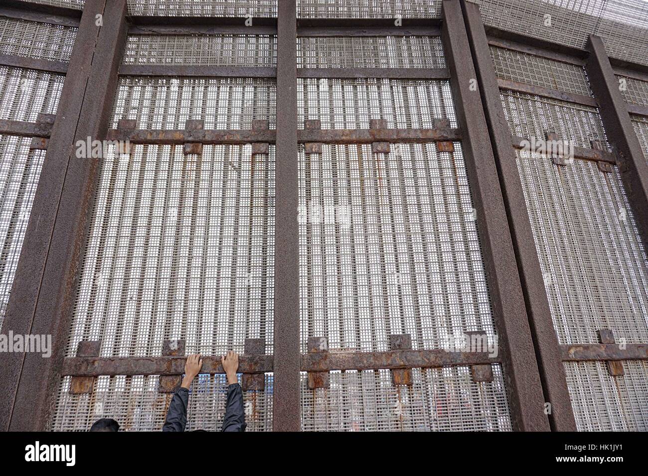 San Ysidro, Stati Uniti d'America. 25 gennaio, 2107. **Foto File** Presidente Trump firmato degli ordini esecutivi per iniziare la costruzione di un muro in US-frontiera messico, potenziare la Pattuglia di Confine forze e aumentando il numero dell'immigrazione i funzionari di polizia incaricati di effettuare le deportazioni. Nella foto: 29 Maggio 2016 - San Ysidro, California, Stati Uniti - Una nazionale messicana sorge lungo gli Stati Uniti-Messico muro di confine. Credito: ZUMA Press, Inc./Alamy Live News Foto Stock