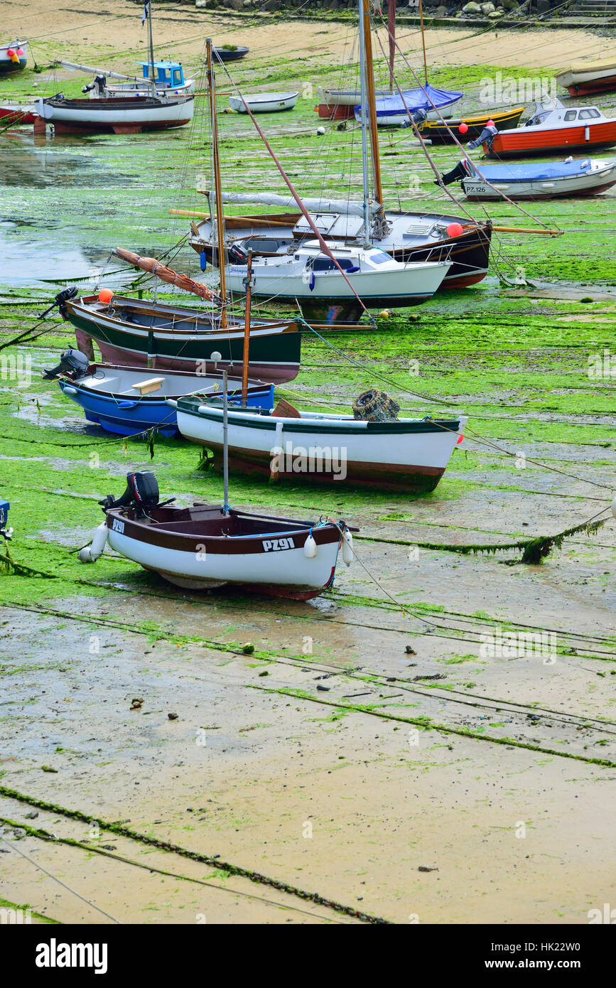 Barche ormeggiate a bassa marea sulla sabbiosa spiaggia nella bellissima pesca & villaggio vacanze di Mousehole sulla South Cornwall coast,Inghilterra, Gran Bretagna Foto Stock