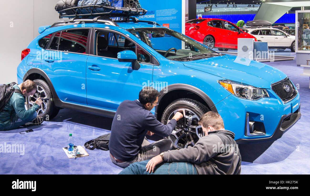 Tre ingegneri reverse-engineering (analisi competitiva) un auto al North American International Auto Show (NAIAS). Foto Stock