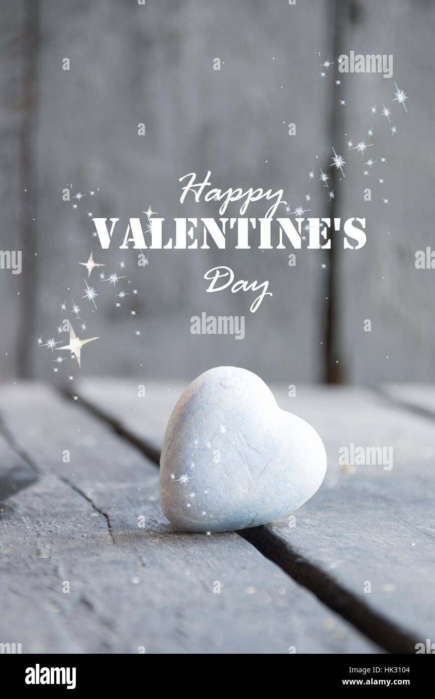 Cuore su un tavolo in legno e felice il giorno di San Valentino del testo Foto Stock