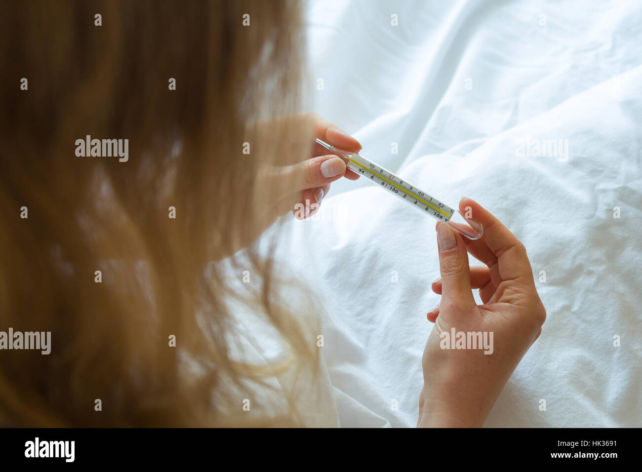 Donna di mano azienda termometro Foto Stock