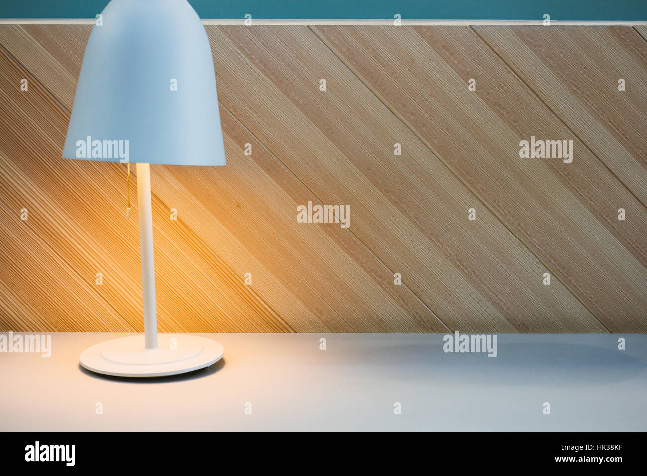 Scrivania minima con lampada da tavolo sulla sinistra lato e sfondo in legno Foto Stock