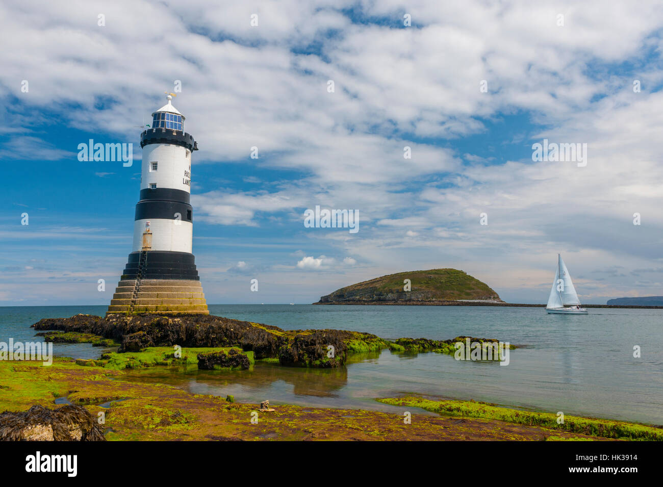 Trwyn Du faro Penmon con yacht e Puffin island in background. Foto Stock