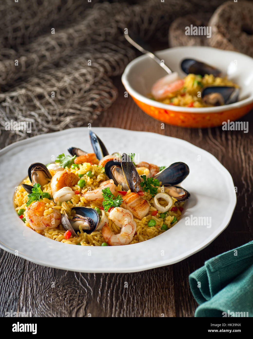 Una ciotola di deliziosi piatti di pesce e di riso con gamberetti, capesante, cozze e calamari anelli. Foto Stock