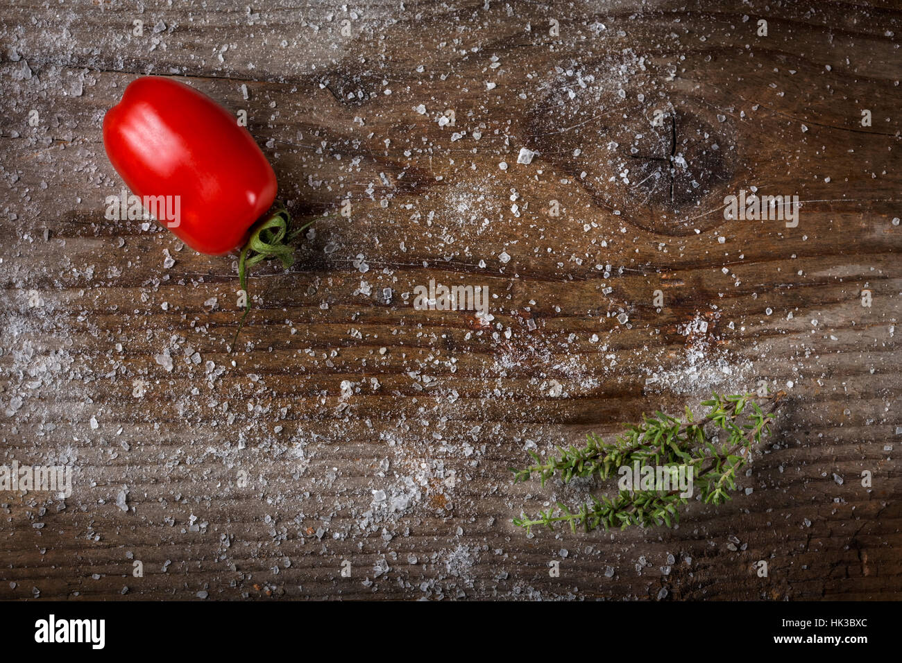 Pomodoro e timo su uno sfondo di legno con sale - Spazio di copia Foto Stock