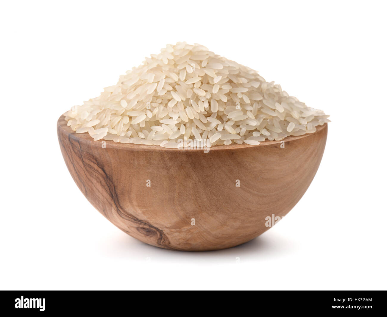 Non cotte riso asciutto in recipiente di legno isolato su bianco Foto Stock