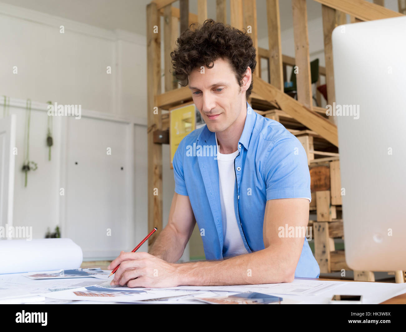 Uomo che lavora con progetti in ufficio Foto Stock
