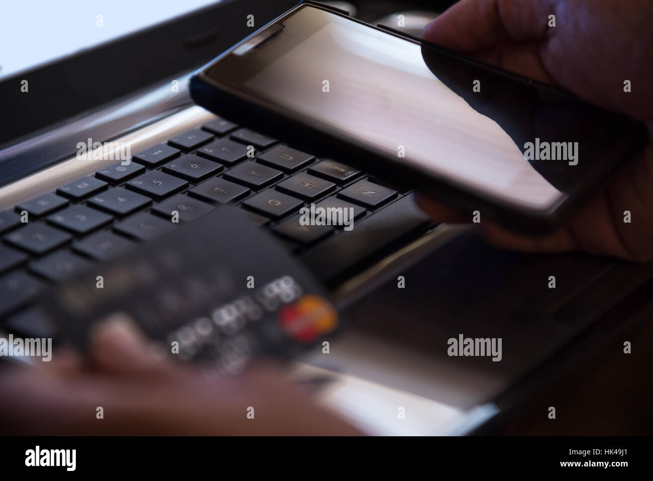 Messa a fuoco selettiva su laptop online il pagamento mobile internet banking concetto nel buio di basso tono tasto Foto Stock