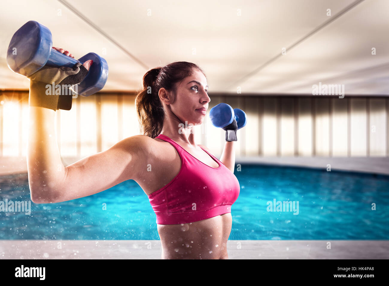 Donna muscolare è la formazione con pesi pesi Foto Stock