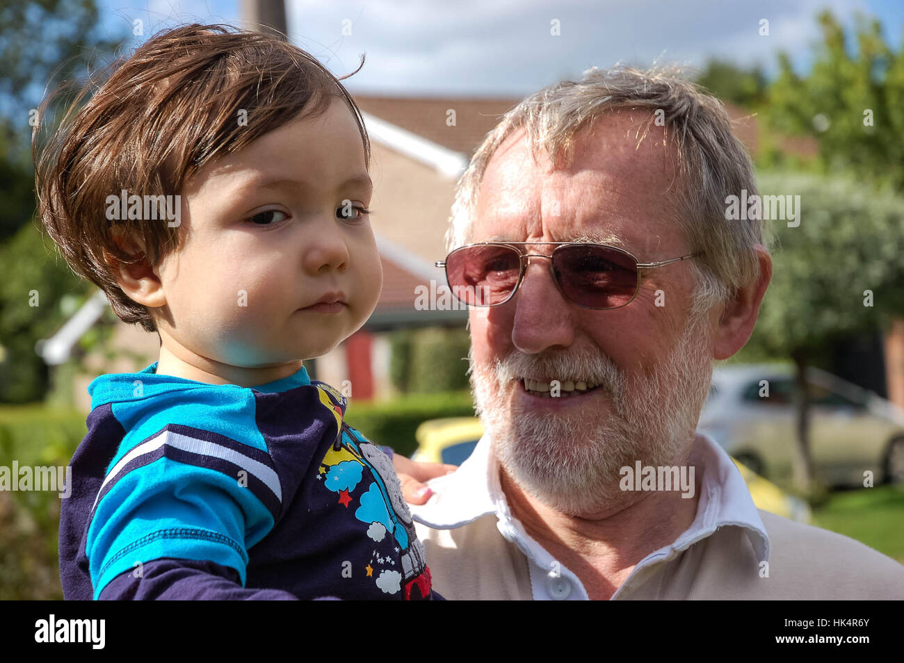 Un sorridente nonno mantiene la sua giovane nipote. Foto Stock