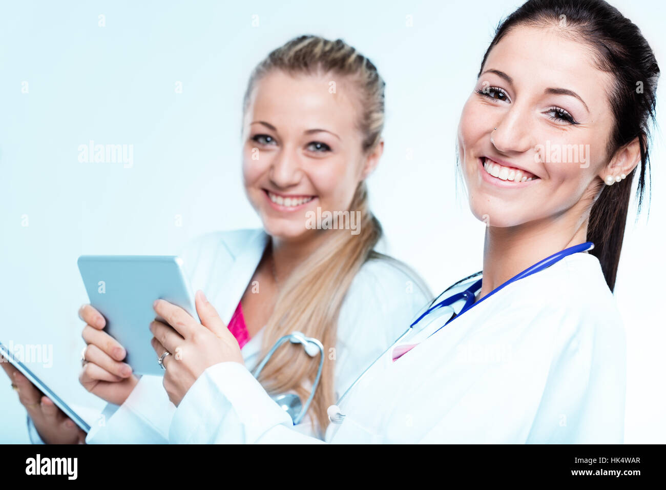 Paio di sorridere i medici e una tavoletta digitale, sono due superbi donne pronti ad aiutare Foto Stock