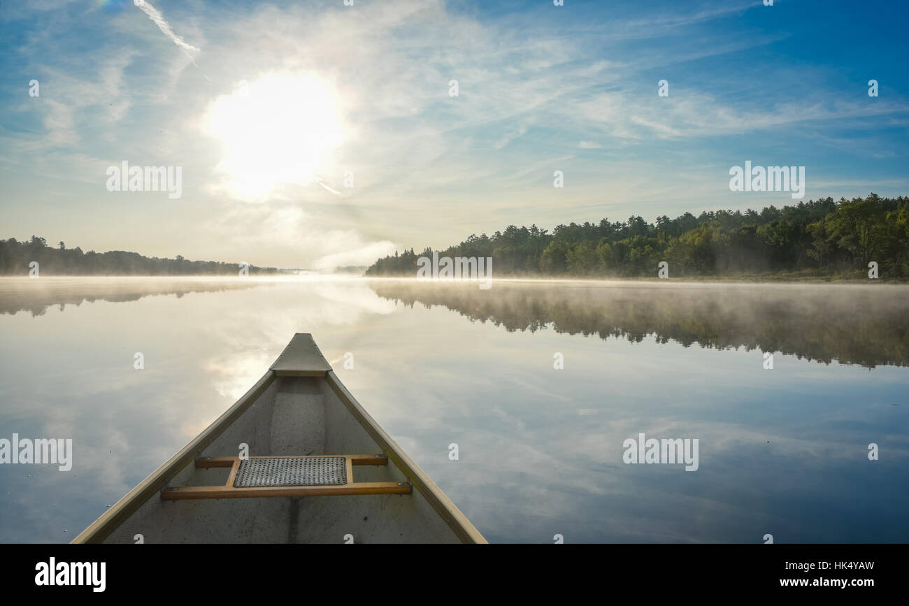 Canoa al mattino. Brillanti e luminose a metà estate sole mattina, paddling una canoa nel mezzo del silenzioso, tranquillo e Corry lago. Foto Stock