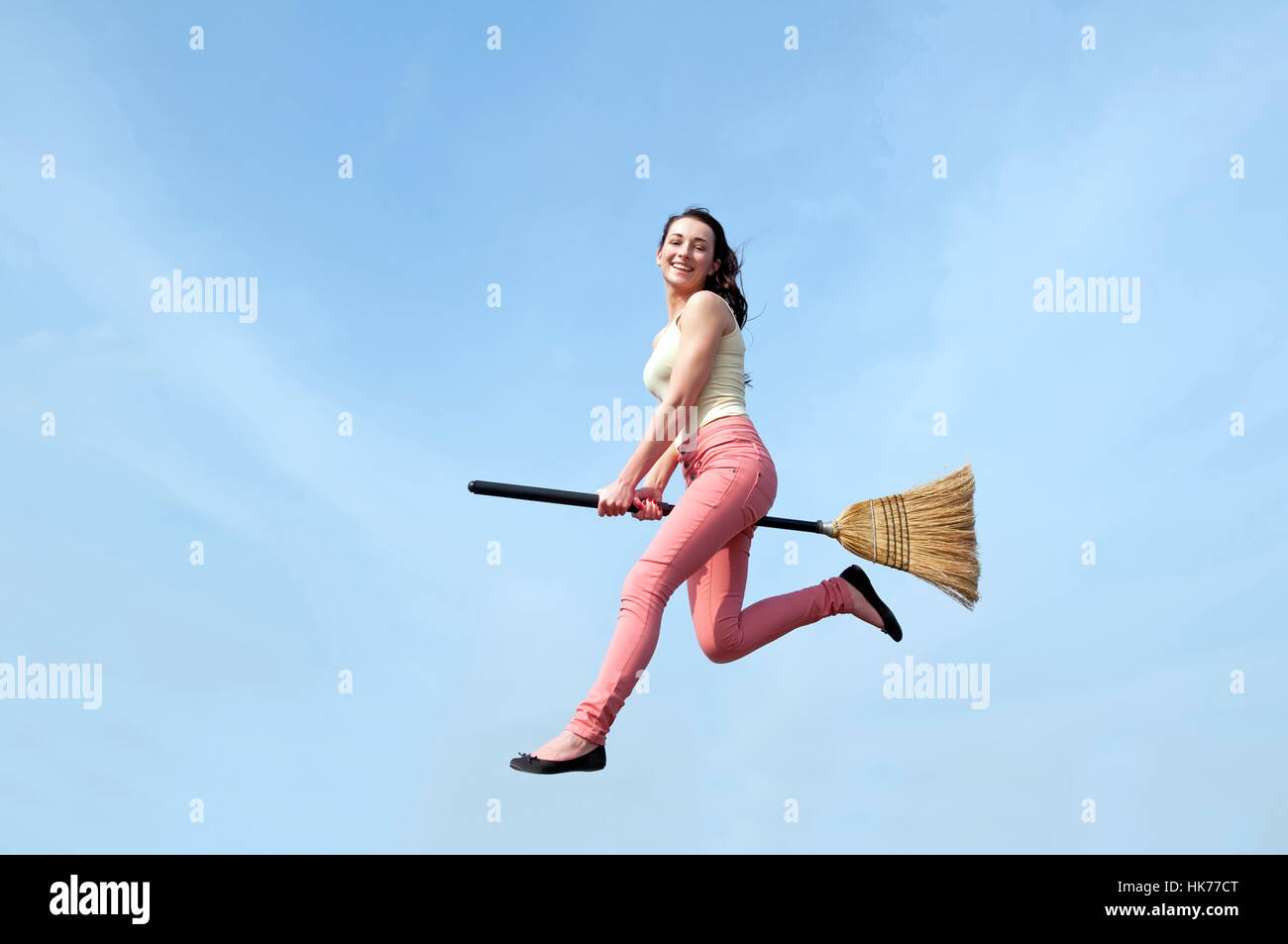 Giovane donna a volare con la scopa Foto Stock