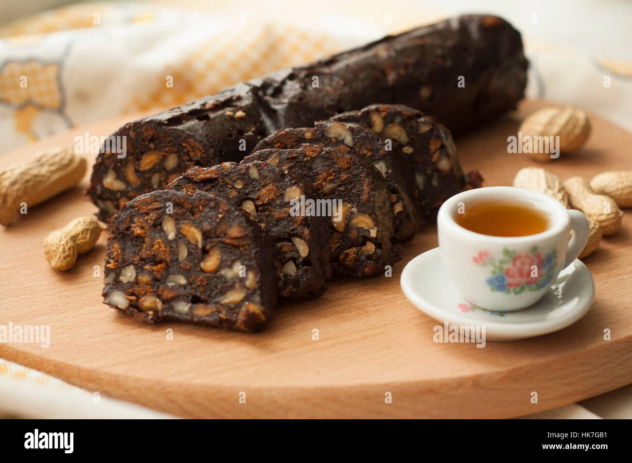 Salame di cioccolato con biscotti e nocciole sul tagliere Foto Stock
