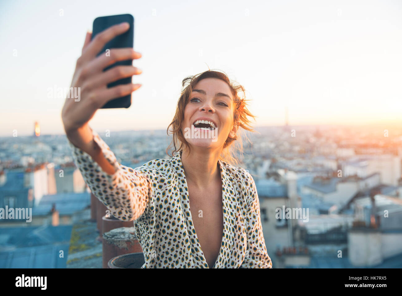Donna facendo un selfie sui tetti di Parigi Foto Stock
