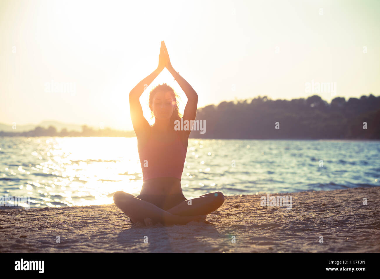 Giovane donna a praticare yoga sulla spiaggia. Foto Stock