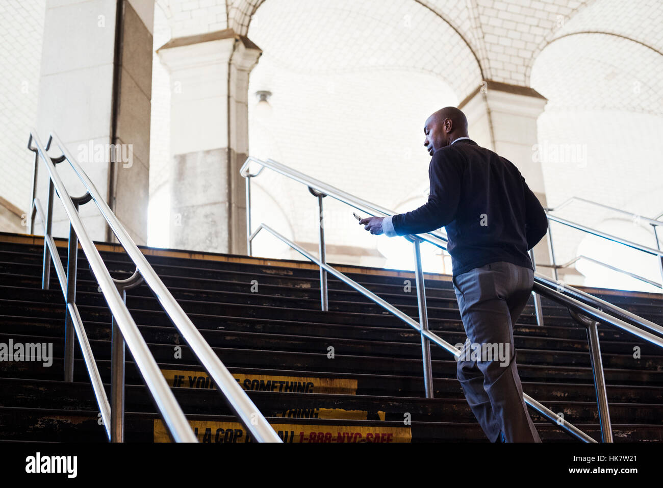 Un uomo salendo una scalinata in un luogo pubblico, sotto un soffitto a volta in Central Park alla metropolitana di New York City STATI UNITI D'AMERICA Foto Stock