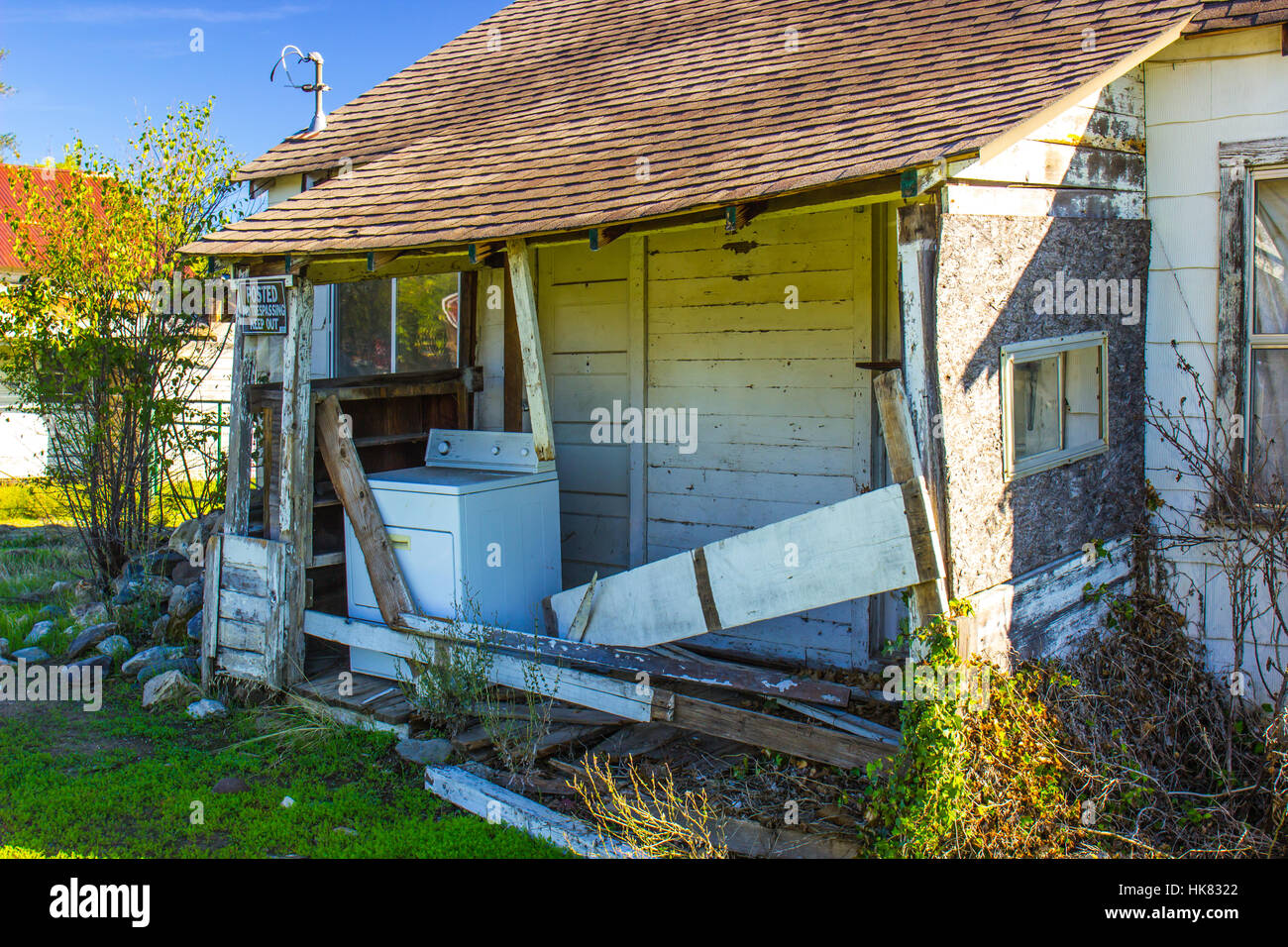 Abbandonato Casa in rovina con macchina di lavaggio sul portico anteriore Foto Stock