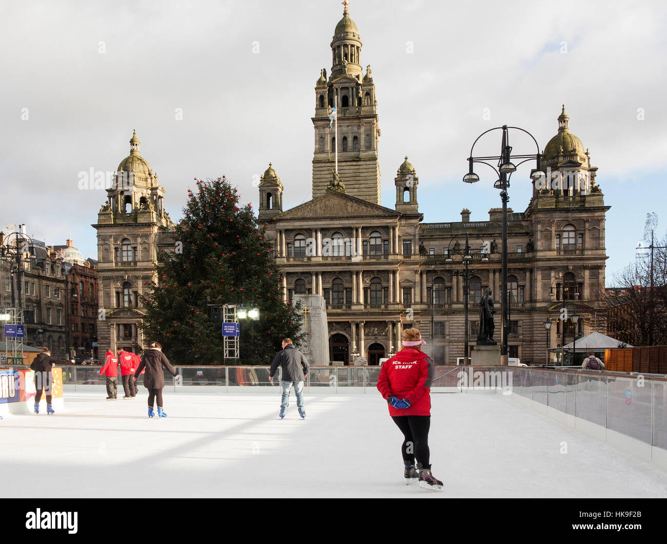 Festosa di pattinaggio a Glasgow George Square sulla temporanea all'aperto Pattinaggio su ghiaccio davanti al City Chambers. Foto Stock