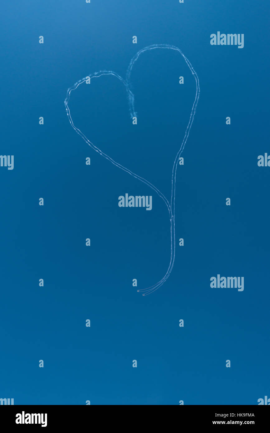 Due planeurs rilasciando fumo, eseguono la forma di un cuore in aria Foto Stock