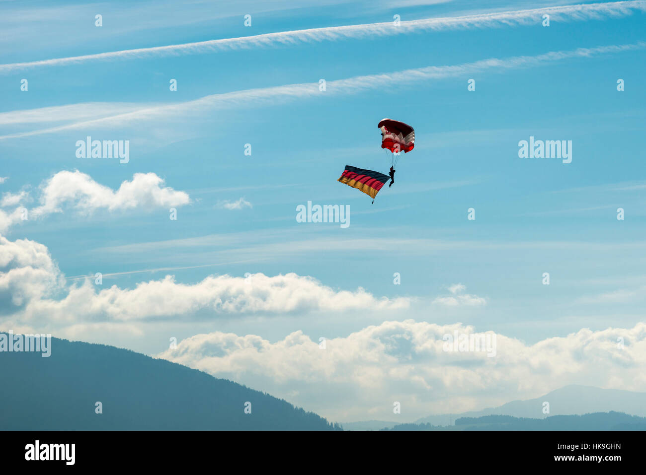 Un parachuter, portando la bandiera della Germania è volare in aria Foto Stock