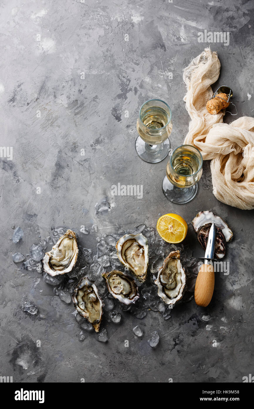 Aprire le ostriche e champagne sul cemento grigio texture di sfondo spazio di copia Foto Stock