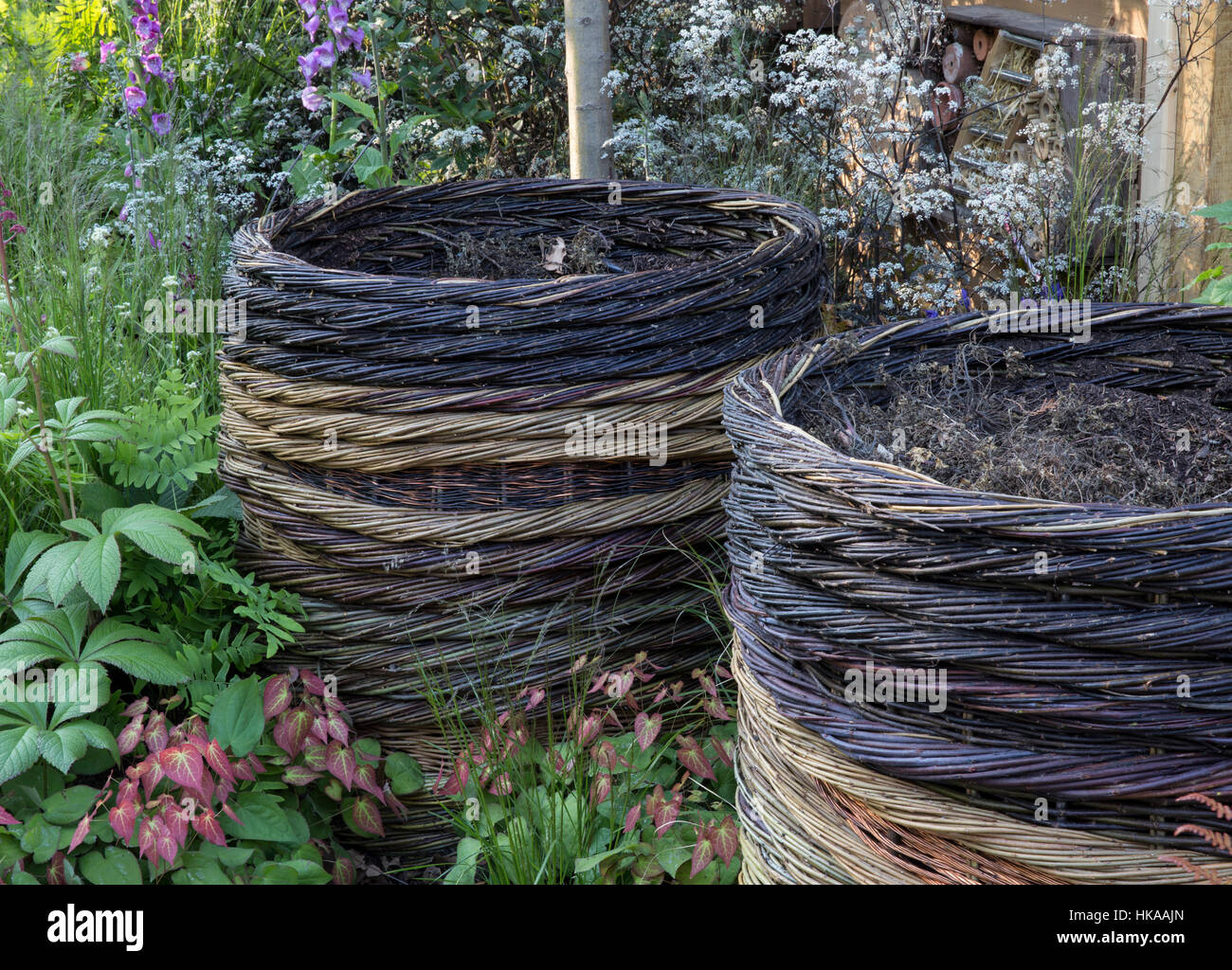 Piccolo giardino ecologico ecologico, adatto alla fauna selvatica, con due contenitori di compostaggio di salice intrecciato, compostatori, Inghilterra GB UK Foto Stock