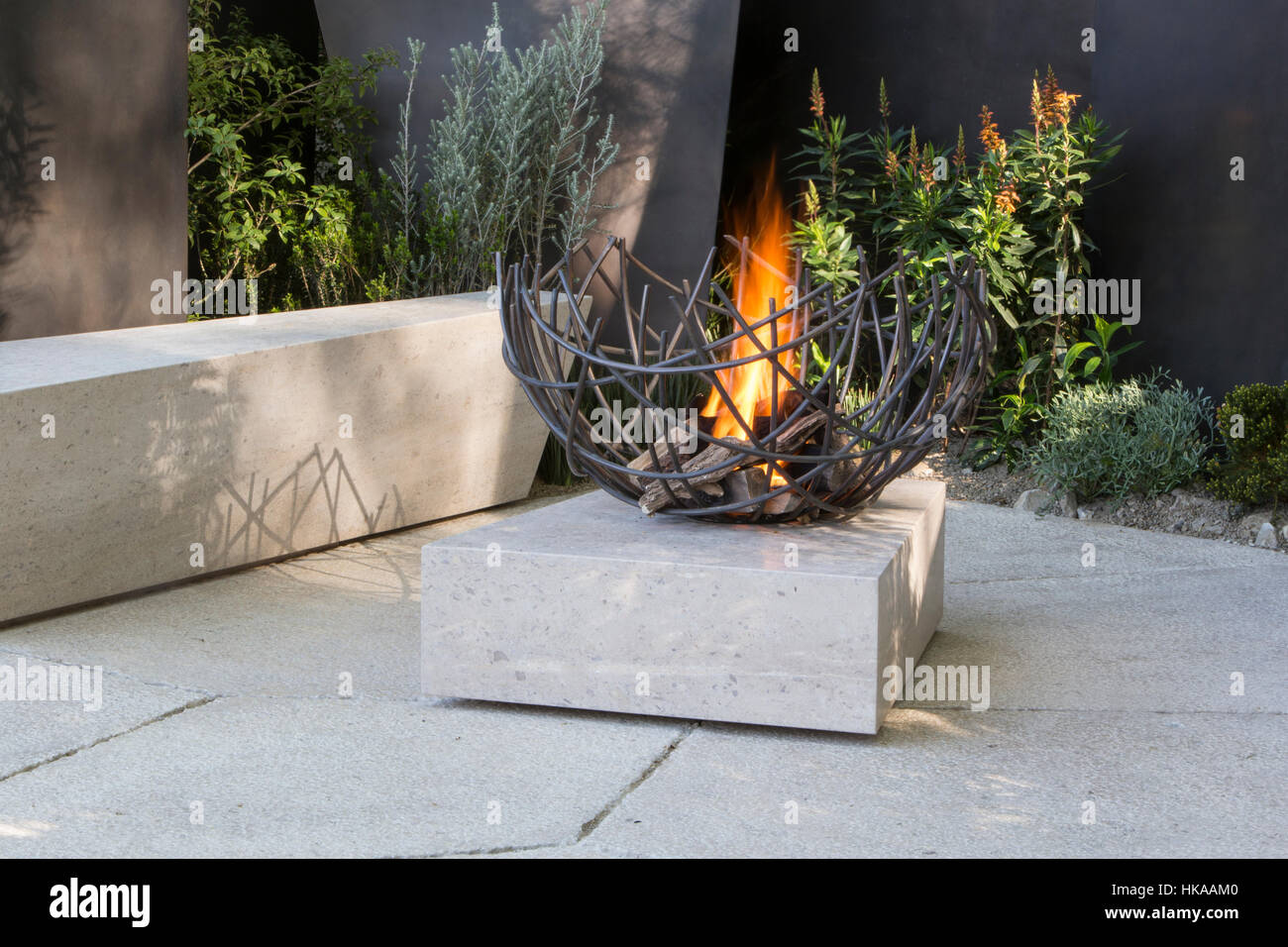 Un moderno patio in pietra con sedile a panca e caminetto all'aperto il Telegraph Garden, Chelsea flower Show 2016 London UK - Designer Andy Sturgeon Foto Stock