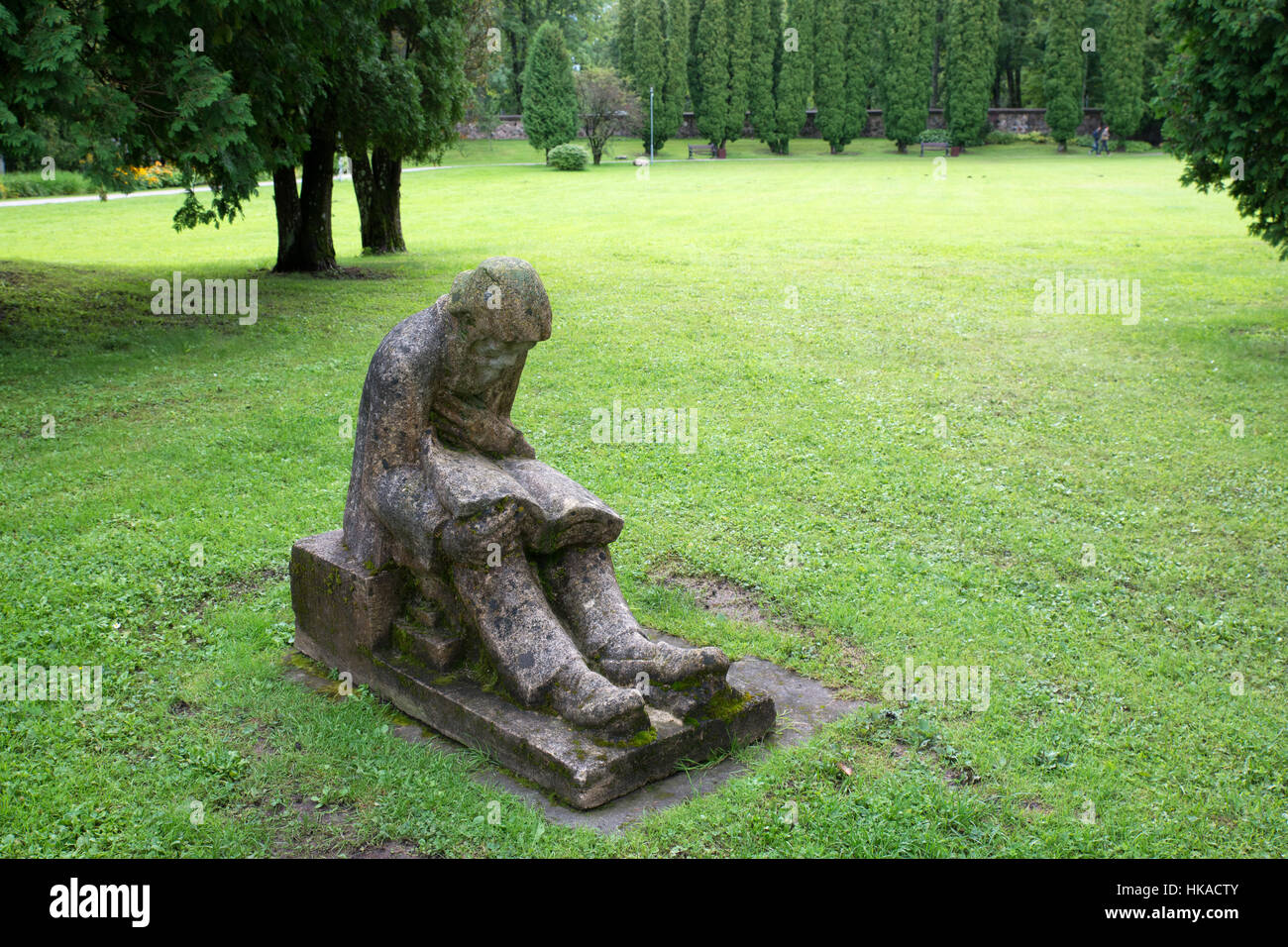 Una statua di un lettore nel prato davanti al castello di Sigulda, Sigulda, Lettonia Foto Stock