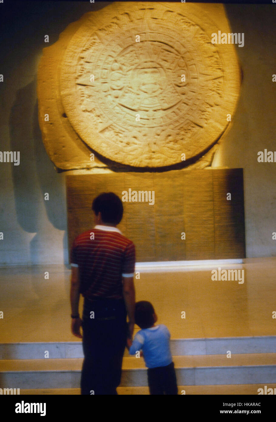 Messico uomo con figlio di fronte a un calendario Azteco Foto Stock