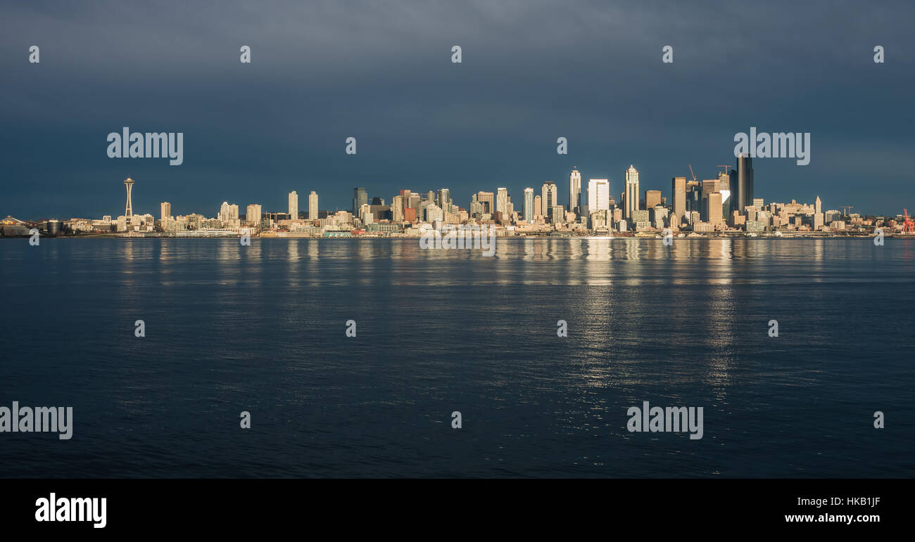 Come il sole tramonta edifici della skyline di Seattle sono riflesse nella Baia di Elliott. Foto Stock