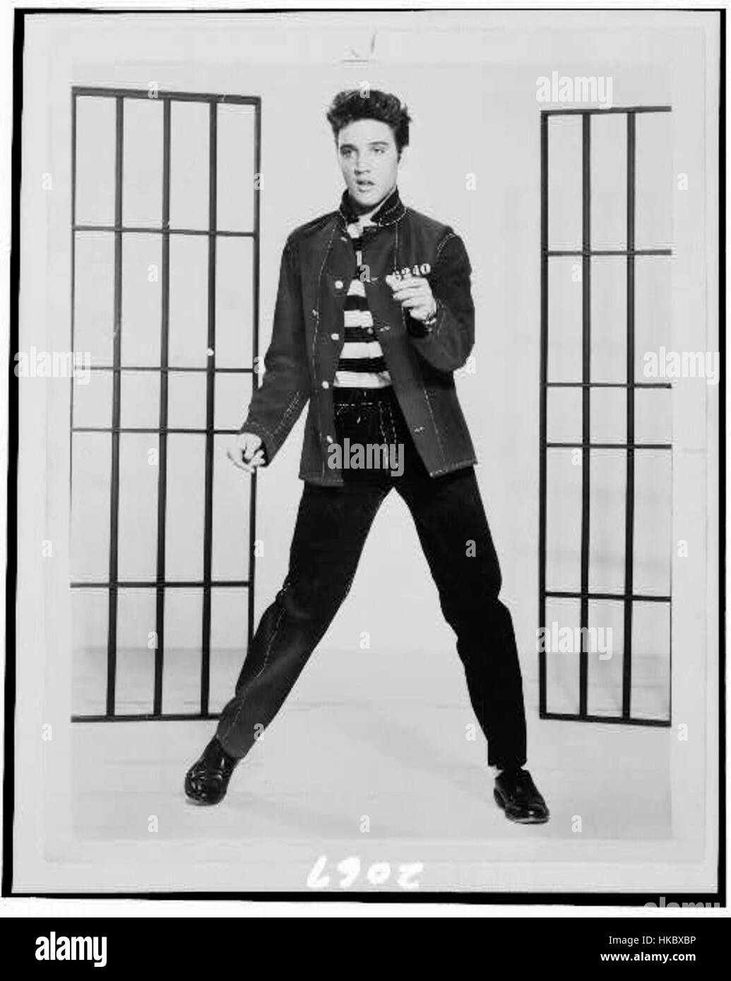 Questa iconica immagine di Elvis Presley che si esibisce nel film *Jailhouse Rock* (1957) cattura una delle scene più famose della sua carriera, mostrando il suo impatto culturale sul rock and roll e il cinema americano degli anni '1950. Foto Stock