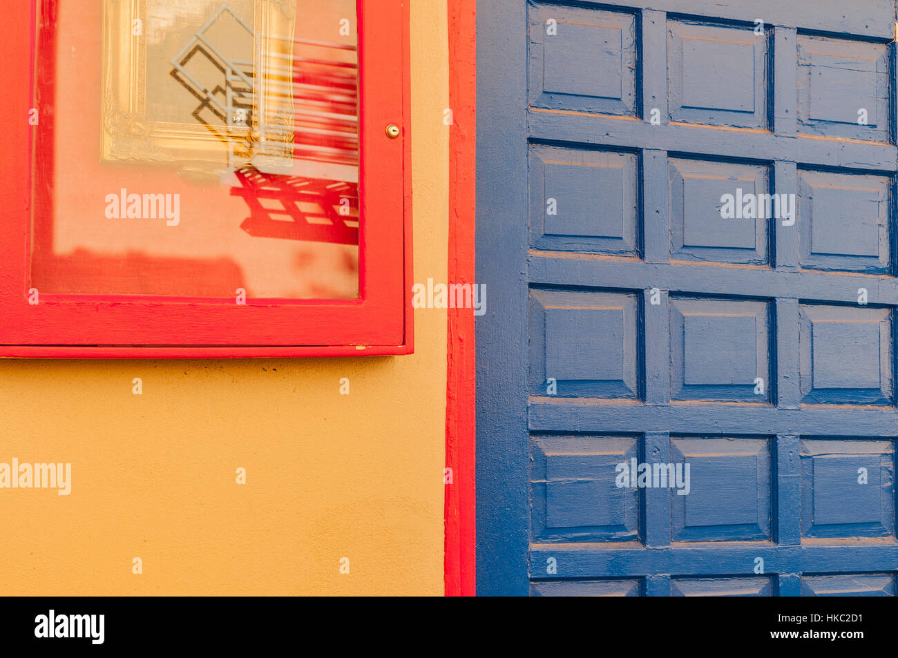 Dettaglio di una porta blu e arancione finestra incorniciata su una parete gialla, nella Città Vecchia, Santa Fe, New Mexico. Foto Stock