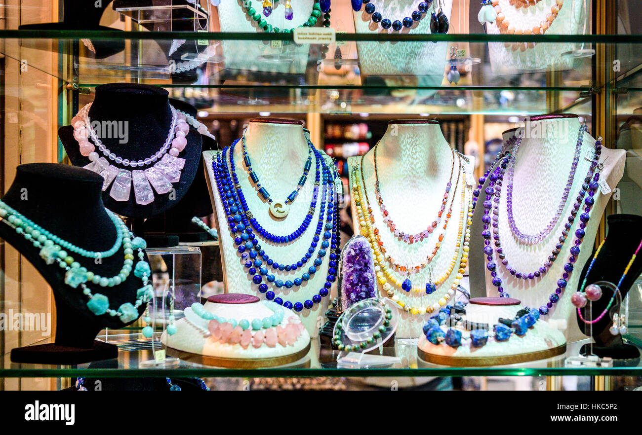 Display con diversi disegni di gioielli fatti a mano su supporto. Close-up di gioielli fatti a mano shop window display. Varietà di orecchini, collane, anelli, b Foto Stock