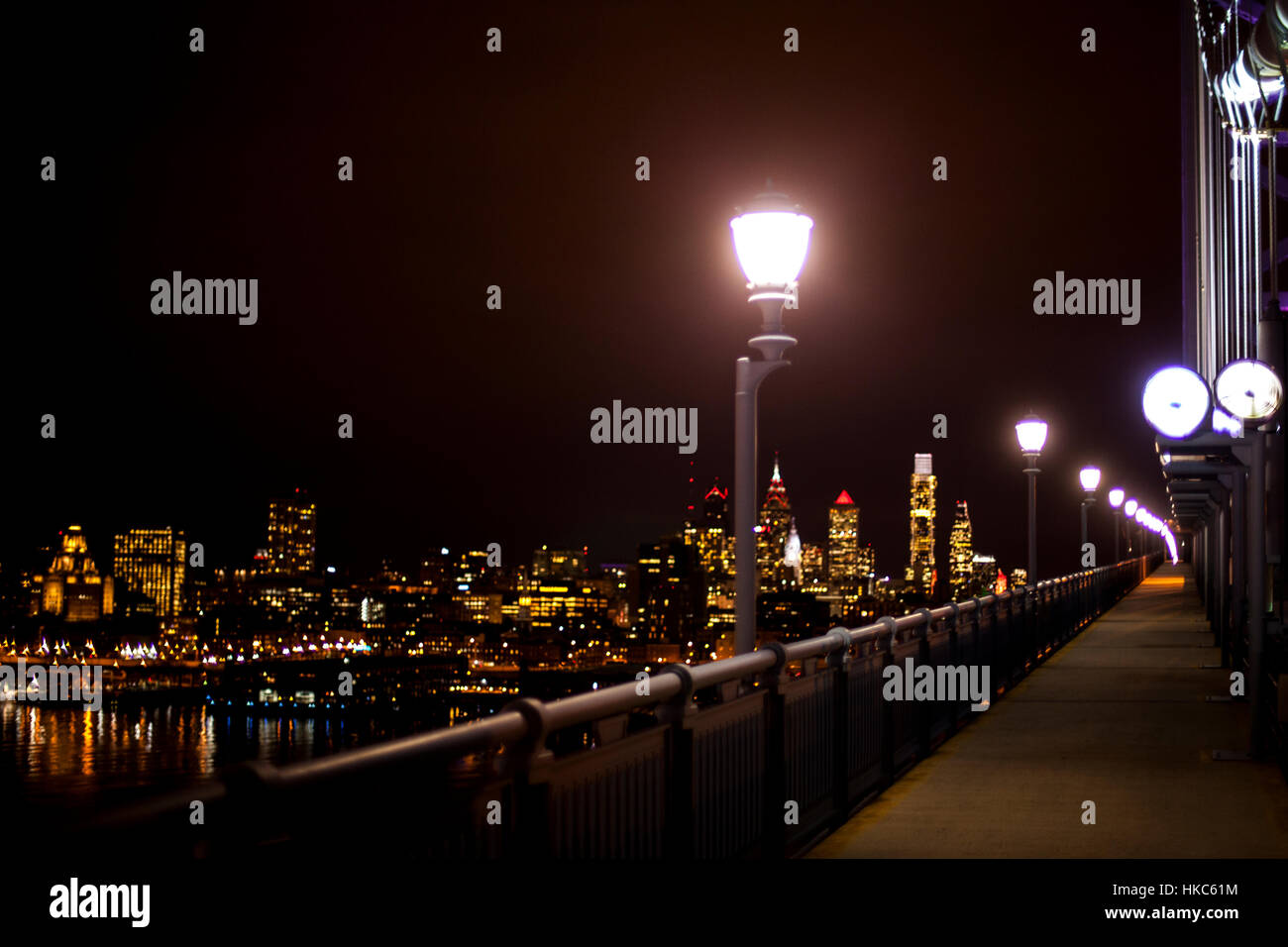 Lampione con una strada luce su una città illuminata sullo sfondo Foto Stock