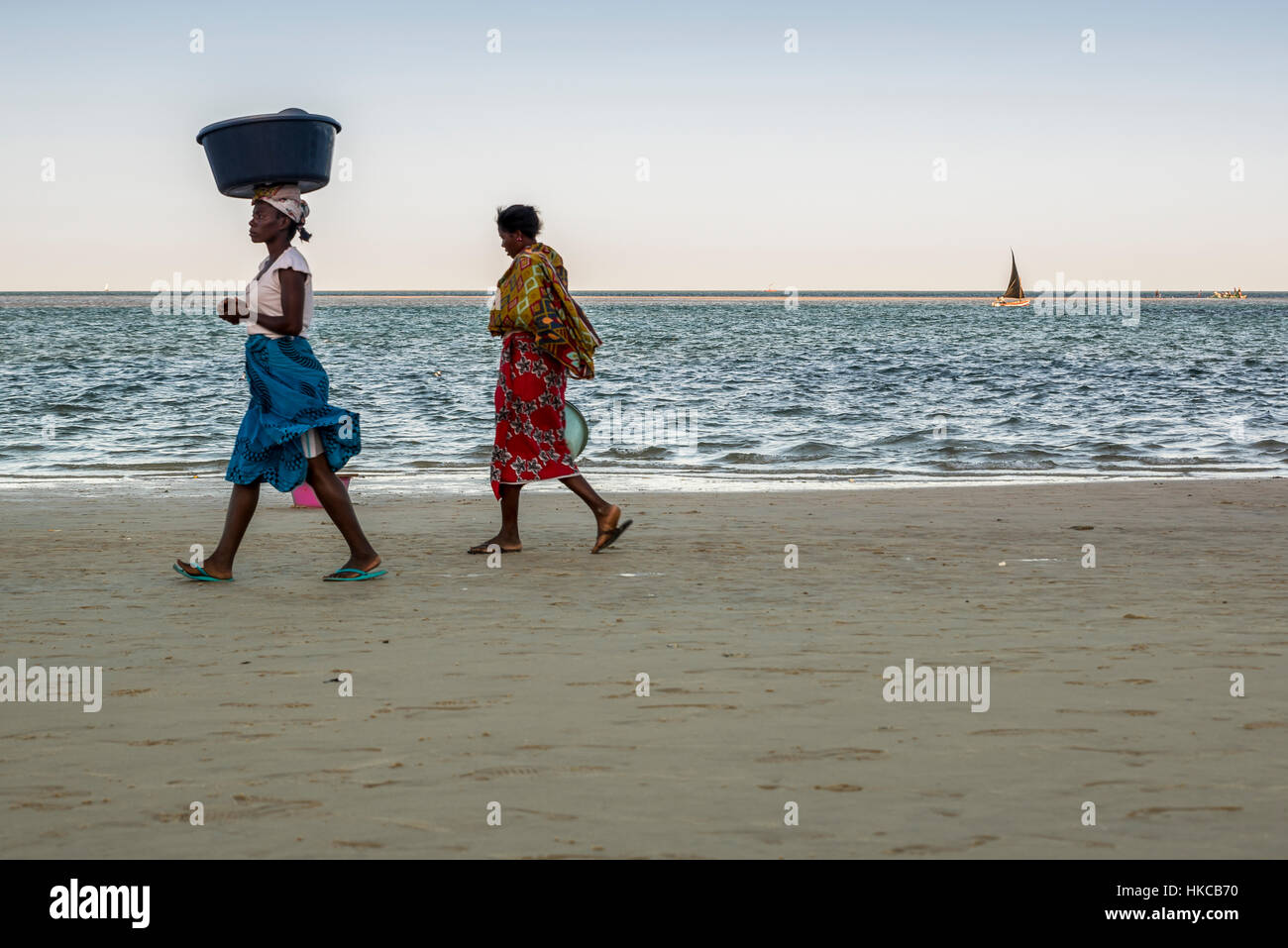 Donne locali di attesa per i pescatori che arrivano sulla loro Dhow, Vilanculos beach; Arcipelago di Bazaruto, Mozambico Foto Stock