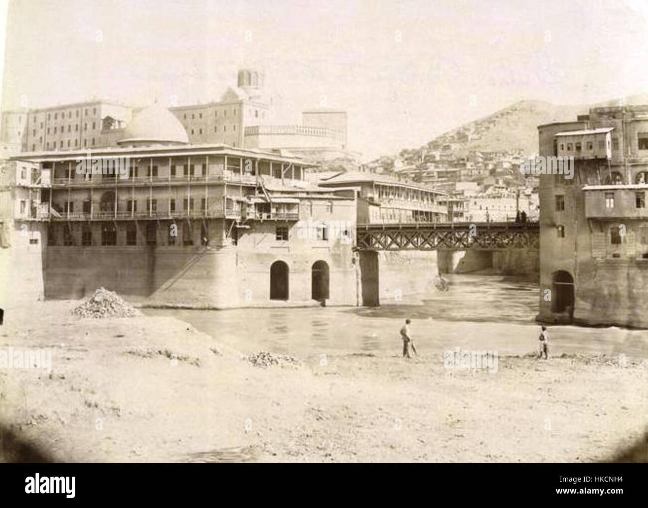 Questo dipinto, intitolato "Ponte al bazar tataro", raffigura il famoso ponte di Tiflis (l'odierna Tbilisi), Georgia, che conduce al bazar tataro. Cattura la vibrante atmosfera culturale e commerciale di questa zona storica. Foto Stock