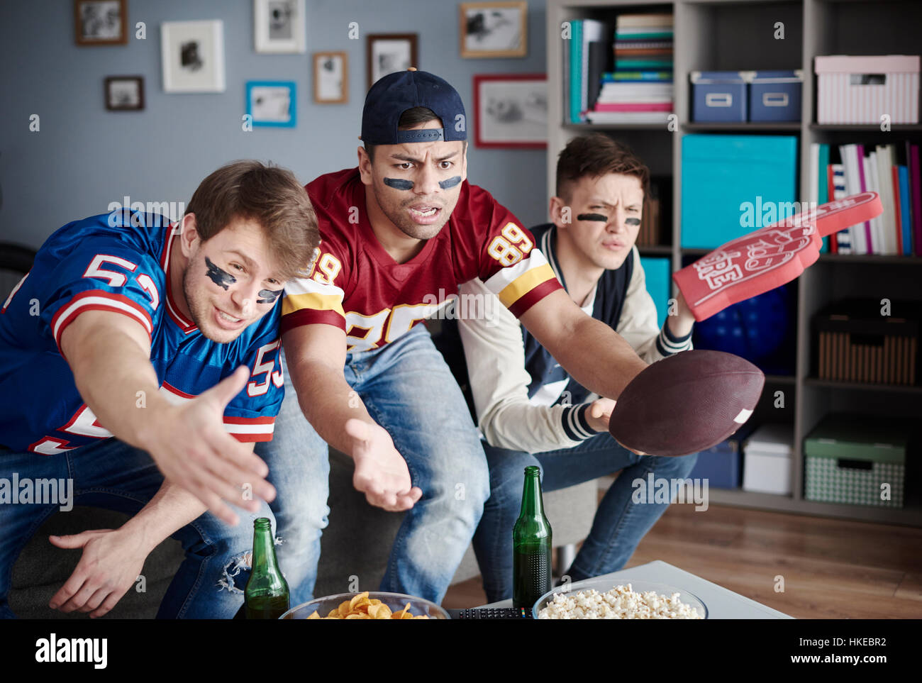 Infelici uomini mentre si guarda il football americano Foto Stock