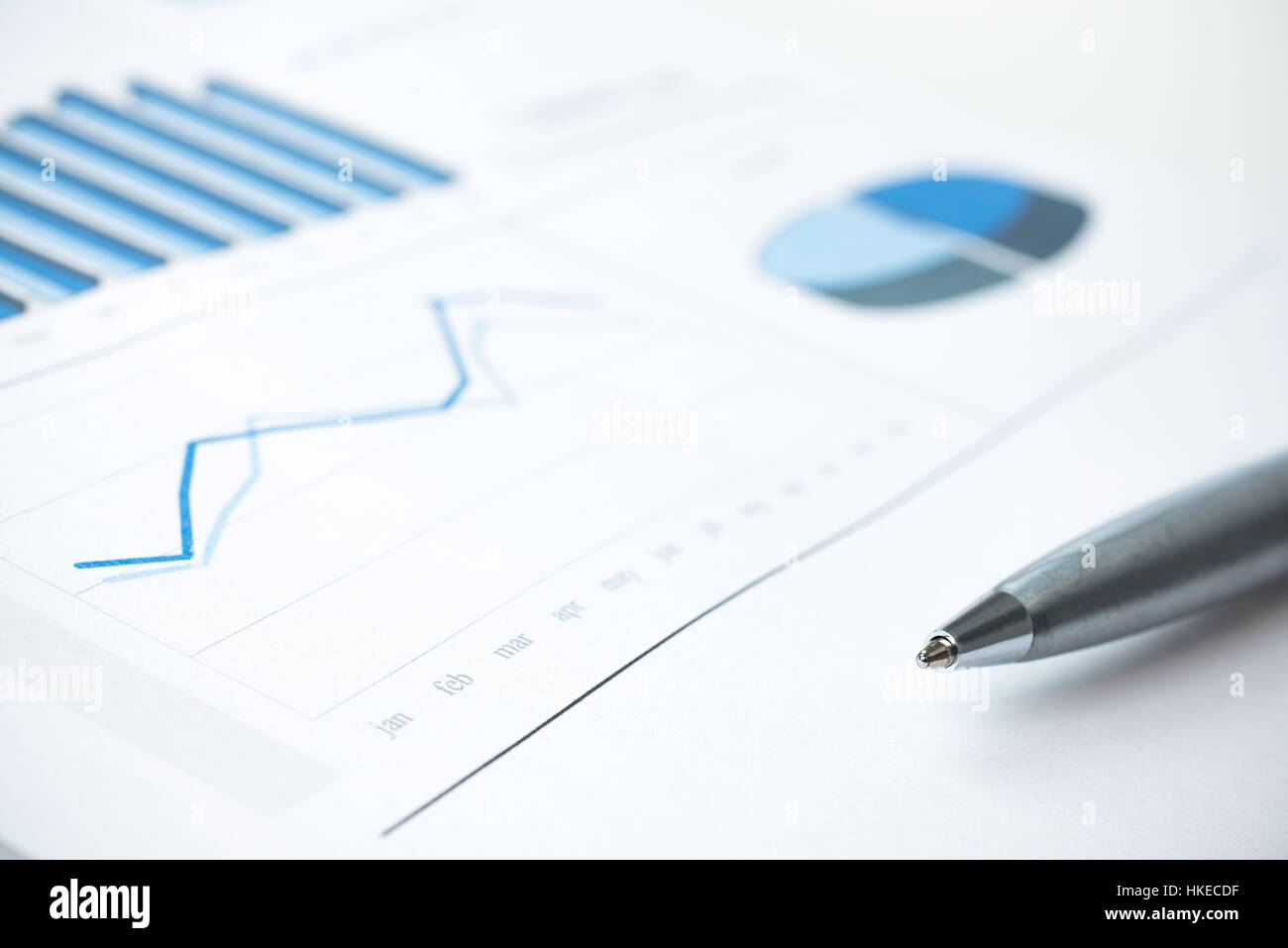 Dati aziendali report grafico e chiudere verso l'alto. Statistiche mensili. Colore di inchiostro di stampa della carta e penna. Messa a fuoco selettiva. Nei toni del blu Foto Stock