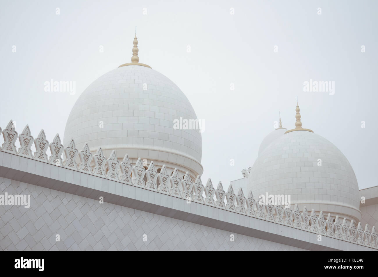 Cupole bianche di una Moschea di Abu Dhabi contro un cielo di nebbia Foto Stock