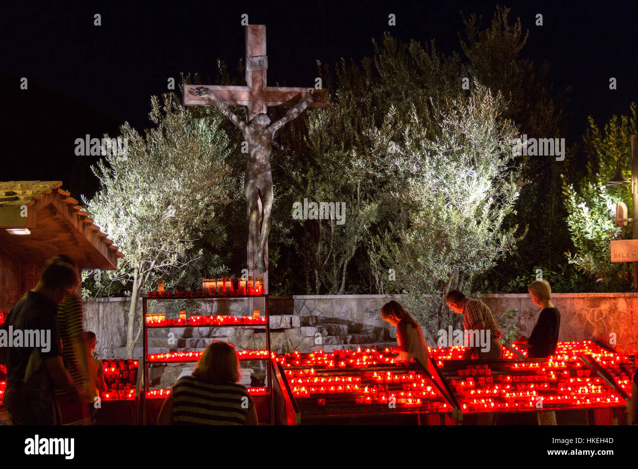 Pellegrini venuti alla luce di una candela davanti alla Croce vicino al Saint James chiesa. Foto Stock