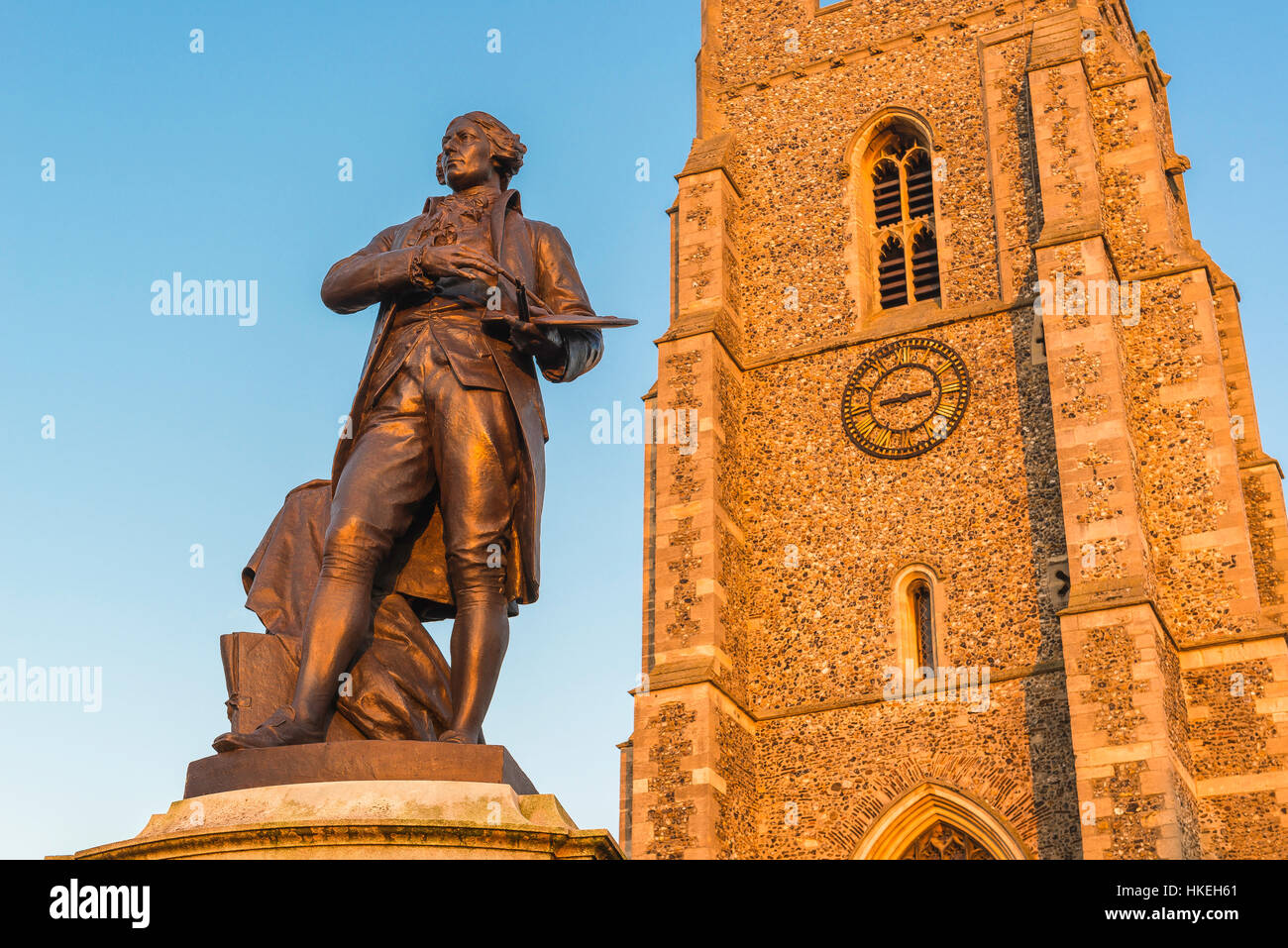Sudbury Suffolk UK, vista della statua di Thomas Gainsborough e della torre della chiesa di San Pietro situata nella piazza del mercato di Sudbury, Inghilterra, Regno Unito Foto Stock