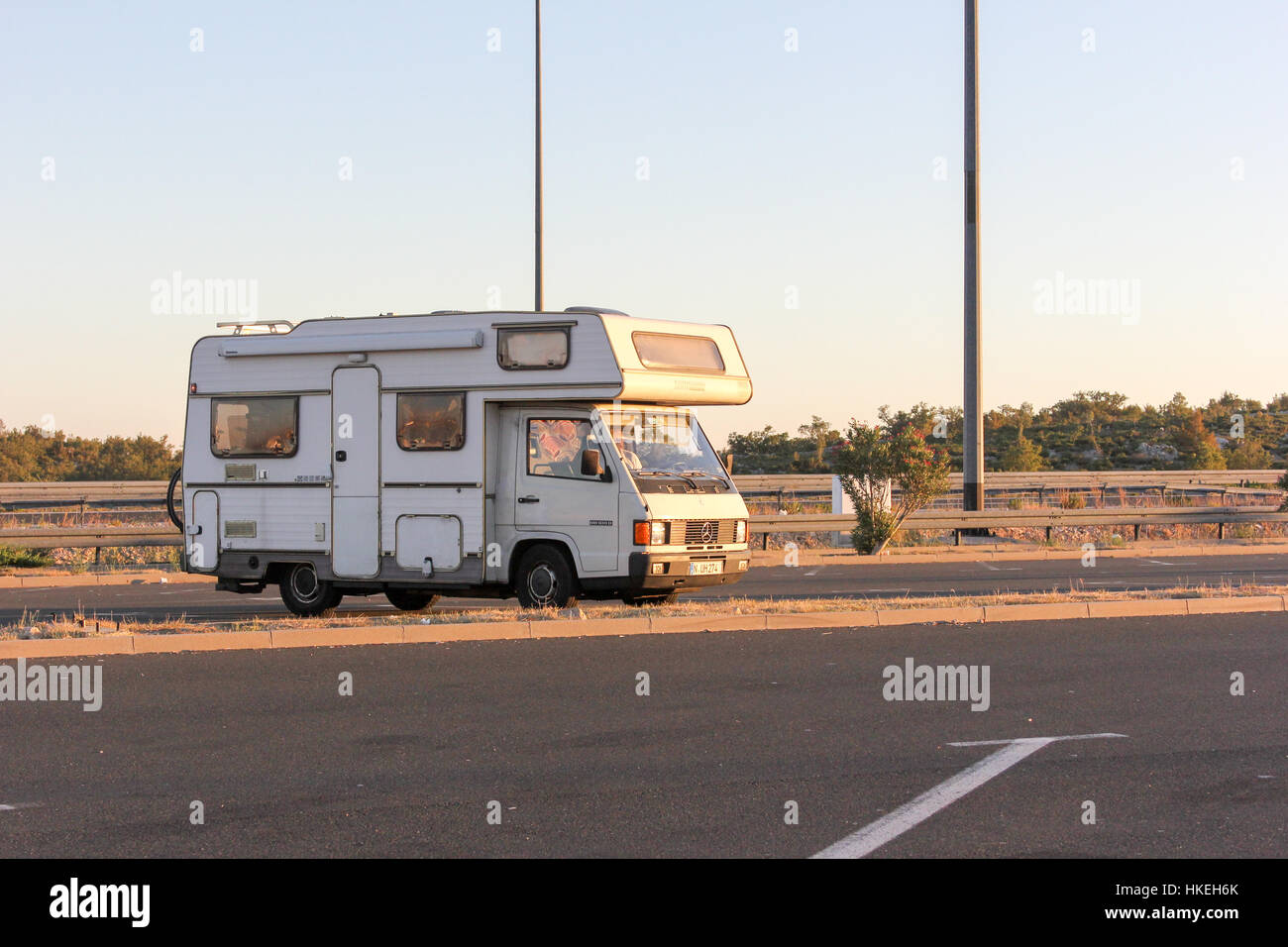 Croazia, 15/08/2016. Un vecchio RV auto parcheggiate in corrispondenza di un vuoto parcheggio auto da qualche parte in Croazia. Foto scattata al tramonto. Foto Stock