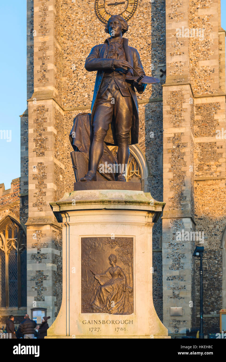 Sudbury UK, vista della statua di Thomas Gainsborough e la torre della chiesa di San Pietro si trova nella piazza del mercato di Sudbury, Inghilterra, Regno Unito Foto Stock