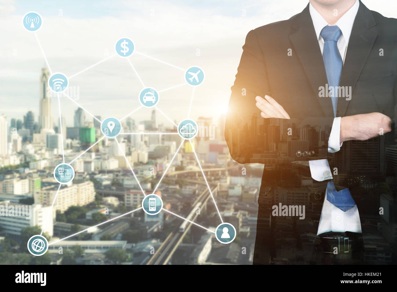 La doppia esposizione imprenditore in piedi con le braccia incrociate con la tecnologia e l'icona di comunicazione. Foto Stock