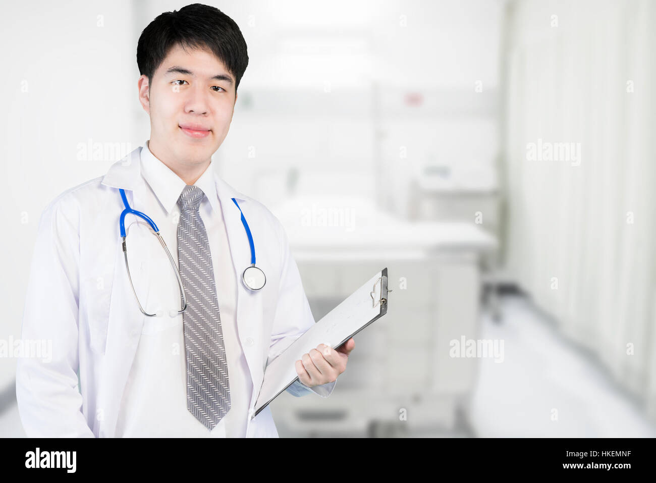 Asian medico in ward tenendo un clipboard al moderno ospedale. Di medico e di medico concetto. Foto Stock