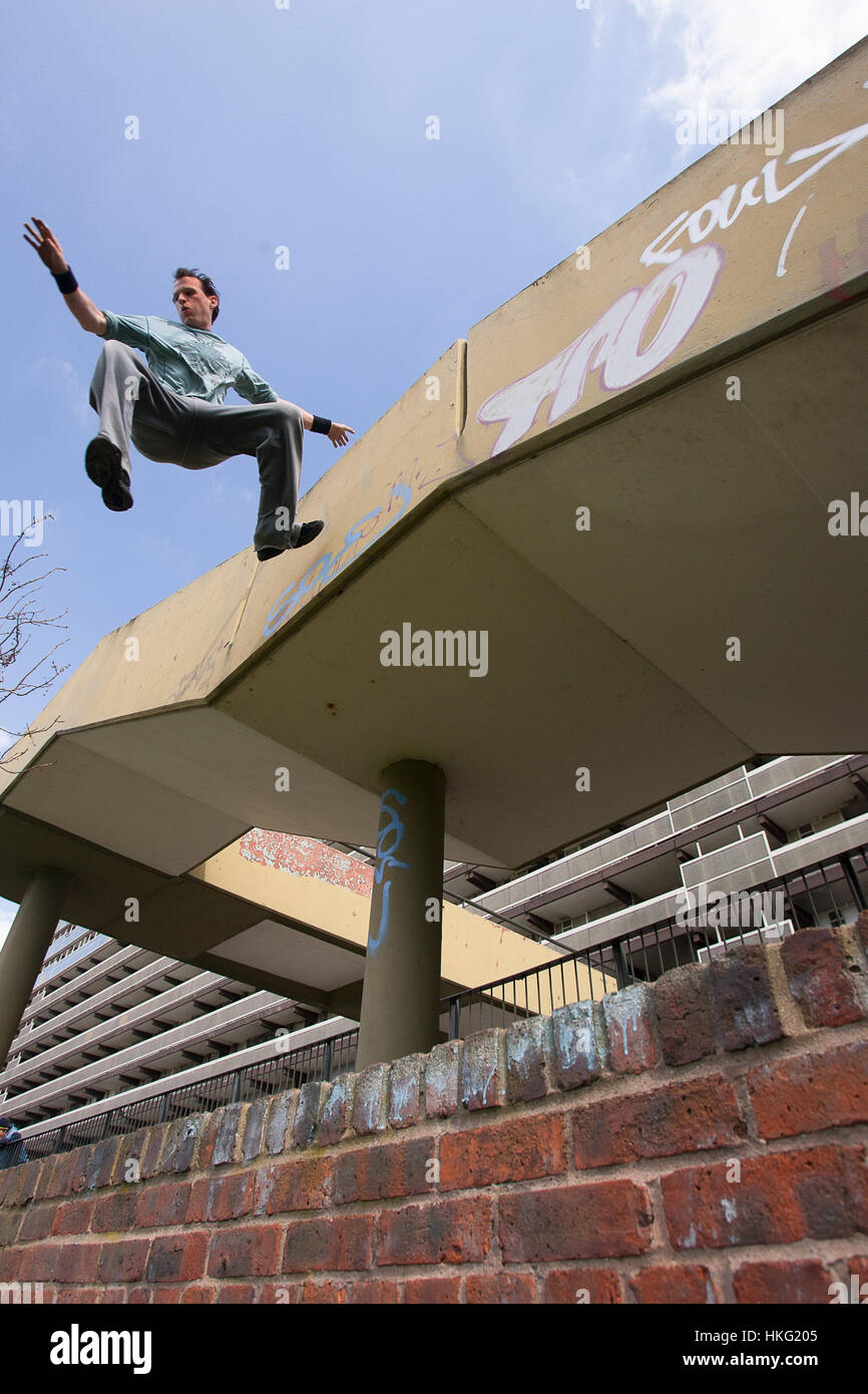 Un parkour freerunning atleta saltare giù da un marciapiede Foto Stock